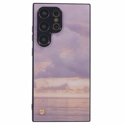 A smartphone with a purple and pink sunset case featuring an ocean view with subtle cloud formations. 