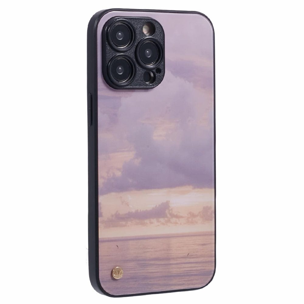 A smartphone with a purple and pink sunset case featuring an ocean view with subtle cloud formations. 