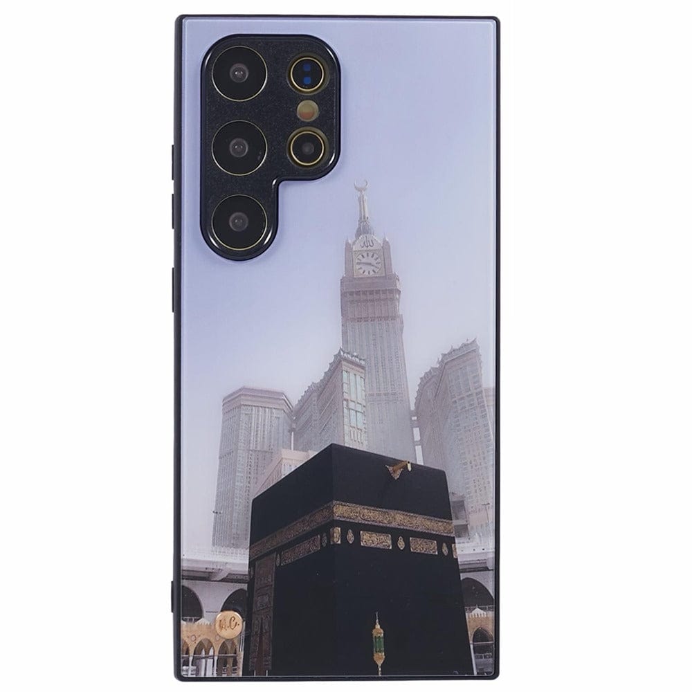 A smartphone with a protective case featuring an image of the Kaaba at the center, with the Abraj Al Bait clock tower in the background, both located in Mecca, Saudi Arabia. 